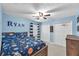 blue bedroom featuring a bed with a space-themed comforter, a ceiling fan, and white closet doors at 7414 Mint Julep Dr, Riverview, FL 33578