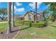 Beautifully landscaped front yard featuring mature palm trees, lush green lawn, and a well-maintained exterior at 7414 Mint Julep Dr, Riverview, FL 33578