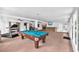 Relaxing enclosed lanai features a pool table, fitness equipment and a wet bar at 7414 Mint Julep Dr, Riverview, FL 33578