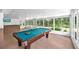 The enclosed lanai features a pool table, wet bar, and views of the green yard at 7414 Mint Julep Dr, Riverview, FL 33578