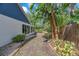 Side yard features a brick-lined walkway, mature plantings, and access to the screened porch at 7414 Mint Julep Dr, Riverview, FL 33578