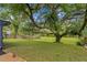 Picturesque backyard showcasing large shade trees and a well-manicured lawn at 7902 River Ridge Dr, Temple Terrace, FL 33637