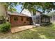 Expansive backyard with a wooden deck, mature trees, and screened-in porch at 7902 River Ridge Dr, Temple Terrace, FL 33637