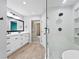 Bright bathroom with double vanity, wood-look flooring, and a glass shower with white subway tile at 7902 River Ridge Dr, Temple Terrace, FL 33637