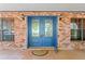 Close up of a blue double front door set in a red brick exterior with matching sconces at 7902 River Ridge Dr, Temple Terrace, FL 33637