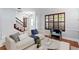 Bright living room featuring hardwood floors, large window with wood shutters, and a staircase at 7902 River Ridge Dr, Temple Terrace, FL 33637