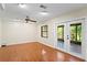 Large living room with hardwood floors, a ceiling fan, and glass doors leading to the enclosed patio at 7902 River Ridge Dr, Temple Terrace, FL 33637