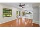 Sunlit living room with hardwood floors, glass doors leading to the patio, and an open view to the kitchen at 7902 River Ridge Dr, Temple Terrace, FL 33637
