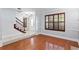 Bright living room featuring hardwood floors, large window with wood shutters, and a staircase at 7902 River Ridge Dr, Temple Terrace, FL 33637