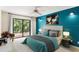 Staged main bedroom features bright blue accent wall and a sliding door to deck at 7902 River Ridge Dr, Temple Terrace, FL 33637