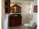 Bathroom featuring a dark wood vanity with black countertop, traditional fixtures and decorative wall art at 819 Satinleaf Ave, Oldsmar, FL 34677