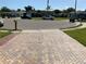 Paver driveway on a corner lot with a well maintained lawn, mature trees, and a cul-de-sac street at 819 Satinleaf Ave, Oldsmar, FL 34677