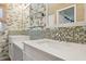 Stylish bathroom features a double sink vanity, tropical wallpaper and mosaic tile backsplash at 8350 Monarch Cir, Seminole, FL 33772