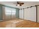 Spacious bedroom with wood floors, bright windows, and decorative sliding barn doors at 8350 Monarch Cir, Seminole, FL 33772