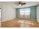 Bright bedroom featuring light wood floors, large windows, and a decorative ceiling fan at 8350 Monarch Cir, Seminole, FL 33772