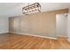 Bright living room with hardwood floors, stylish light fixture, and textured accent wall at 8350 Monarch Cir, Seminole, FL 33772