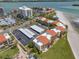 Aerial view of beachfront condos with parking, lush landscaping, and nearby beach at 865 S Gulfview Blvd # 306, Clearwater Beach, FL 33767