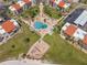 Aerial view of a community pool, lounge chairs, landscaping, and surrounding residential buildings at 865 S Gulfview Blvd # 306, Clearwater Beach, FL 33767
