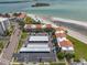 Aerial view shows condo parking, landscaped grounds and beach access to coastal waters at 865 S Gulfview Blvd # 306, Clearwater Beach, FL 33767