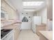 Well-lit kitchen featuring white appliances and light wood cabinetry at 865 S Gulfview Blvd # 306, Clearwater Beach, FL 33767