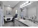 Elegant bathroom with a freestanding tub, granite countertop vanity, and modern fixtures at 9019 S County Line Rd, Lithia, FL 33547