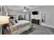 This bedroom features a ceiling fan, dresser, TV, mirror and floral bedding at 9019 S County Line Rd, Lithia, FL 33547