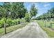 Gated entrance to a property featuring a long driveway and mature landscaping at 9019 S County Line Rd, Lithia, FL 33547