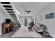 Open-concept living room with a modern staircase, piano, stylish furniture, and a bright front door at 9019 S County Line Rd, Lithia, FL 33547
