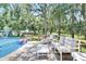 Inviting pool area with deck, lounge furniture, and a fun flamingo float under mature trees at 9019 S County Line Rd, Lithia, FL 33547