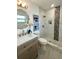 A renovated bathroom featuring marble-style tiled shower, modern vanity and unique mirror at 9308 45Th N St, Pinellas Park, FL 33782