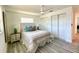 Bright bedroom featuring a ceiling fan, closet, and whitewashed wood laminate flooring at 9308 45Th N St, Pinellas Park, FL 33782