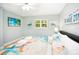 Bright bedroom features a king bed with beach-themed bedding, a TV, and neutral wall color at 1208 Bay Pine Blvd, Indian Rocks Beach, FL 33785
