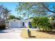 Charming one-story home featuring a sunny front yard, paver driveway, and attached garage at 1208 Bay Pine Blvd, Indian Rocks Beach, FL 33785