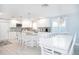Bright, modern kitchen with an island, stainless appliances, and dining area at 1208 Bay Pine Blvd, Indian Rocks Beach, FL 33785