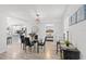 Elegant dining area with modern table, black chairs, and a view into the kitchen and bedroom at 121 Pennsylvania Ave, Palm Harbor, FL 34683
