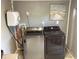 Shot of a gray laundry room with Samsung washer and dryer, and artwork of a beach scene at 121 Pennsylvania Ave, Palm Harbor, FL 34683