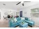 Bright living space featuring a blue sectional, neutral walls, and an open layout to the dining area at 121 Pennsylvania Ave, Palm Harbor, FL 34683