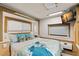 RV bedroom featuring a queen bed, tv and bright, coastal-themed bedding at 121 Pennsylvania Ave, Palm Harbor, FL 34683