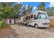 Exterior of a white RV, with attached awning, and outdoor furniture on a gravel lot at 121 Pennsylvania Ave, Palm Harbor, FL 34683