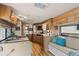 RV kitchen and dining area with wood cabinets, modern appliances, and dinette seating at 121 Pennsylvania Ave, Palm Harbor, FL 34683