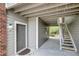 Condo entrance with gray door, gray siding, and white trim; exterior staircase to units above at 1400 Gandy N Blvd # 1701, St Petersburg, FL 33702