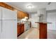 Kitchen with wood cabinets, tile floor, white appliances, and breakfast bar at 1400 Gandy N Blvd # 1701, St Petersburg, FL 33702