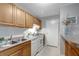 Bright kitchen with wood cabinets, white appliances, tile floors, and breakfast bar at 1400 Gandy N Blvd # 1701, St Petersburg, FL 33702