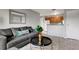 View of living room with gray sofa and chair, wood-look flooring, and view into kitchen at 1400 Gandy N Blvd # 1701, St Petersburg, FL 33702