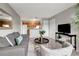 Living room with gray sofa and chair, wood-look flooring, and view into kitchen at 1400 Gandy N Blvd # 1701, St Petersburg, FL 33702