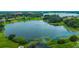 Scenic aerial view of a beautiful lake surrounded by lush greenery and upscale homes at 14174 Thoroughbred Dr, Dade City, FL 33525