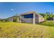 Spacious backyard featuring a screened-in patio, lush green grass, and mature trees at 14174 Thoroughbred Dr, Dade City, FL 33525