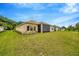 Lush backyard with new construction home, screened patio, and expansive lawn space at 14174 Thoroughbred Dr, Dade City, FL 33525