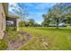 Expansive backyard with lush green lawn, mature trees, and a screened patio on the home at 14174 Thoroughbred Dr, Dade City, FL 33525