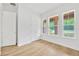 Bright bedroom featuring natural light through multiple windows, closet, and wood-style flooring at 14174 Thoroughbred Dr, Dade City, FL 33525